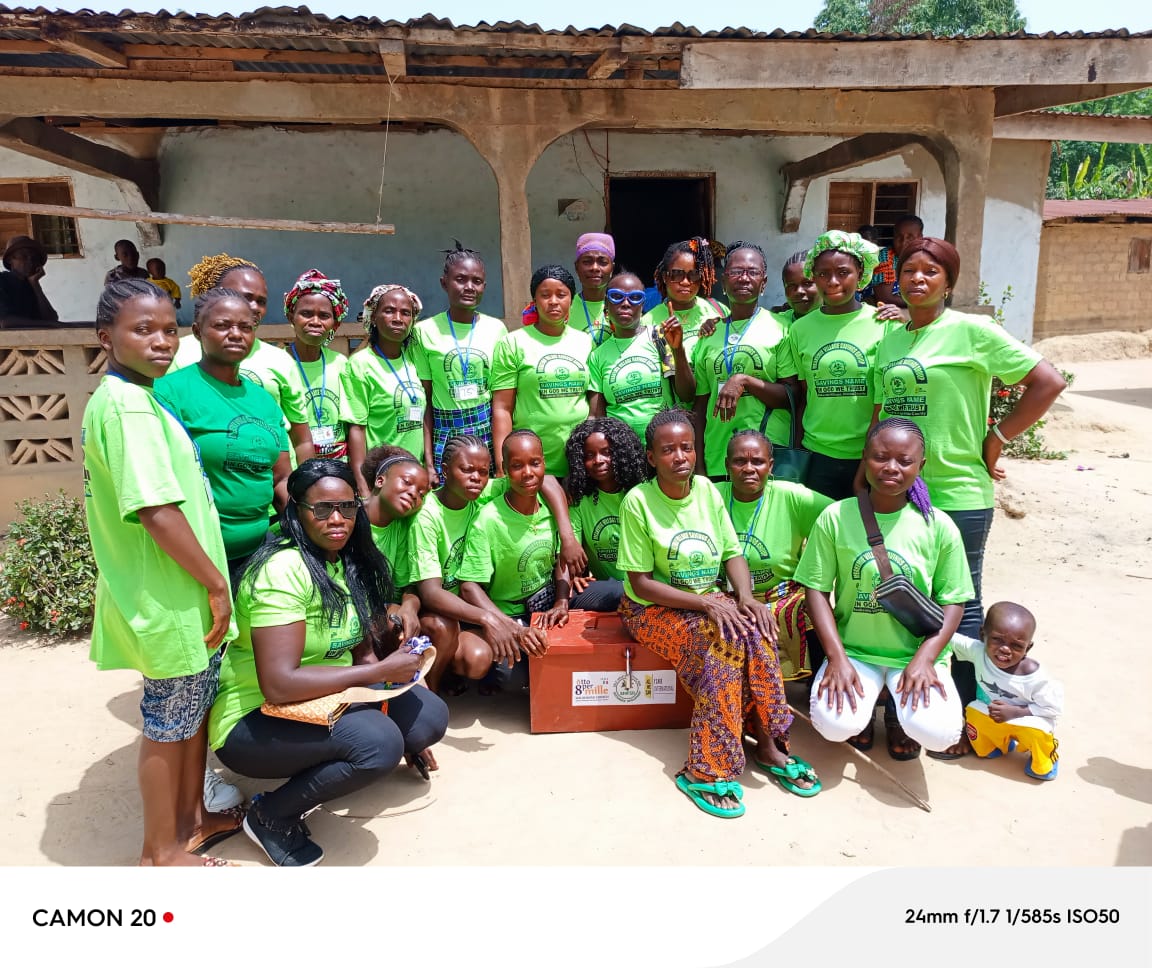 VSLA women's savings group in green SHIFSD shirts with savings box in Nimba County
